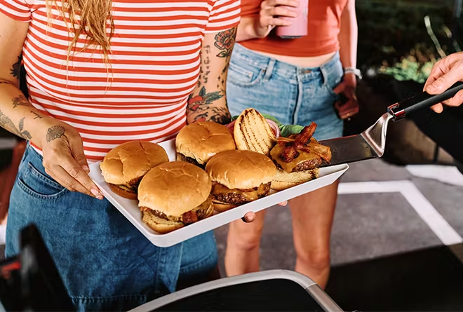 Weber Q Series in action at a college football tailgate – portable grilling, friends, and fire